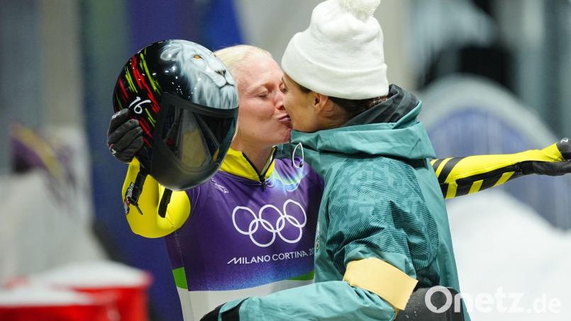 Die belgische Skeletonfahrerin Kim Meylemans (links) und ihre Frau Nicole Silveira, die für Brasilien antrat, küssen sich im Ziel. Bild: Michael Kappeler/dpa