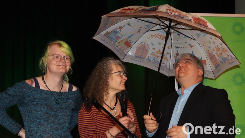 Ein Regenschirm, den Elli Wolf und Yvonne Rösel (von links) Stefan Schmidt überreichten, soll den Bundestagsabgeordneten von Bündnis90/Die Grünen "vor den Tränen des Bundeskanzlers schützen, falls die Grünen bei der Kommunalwahl als Gewinner hervorgehen". Bild: mfh