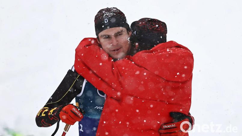 Kombinierer Vinzenz Geiger muss nach der vergebenen Olympia-Medaille von Johannes Rydzek getröstet werden. Bild: Daniel Karmann/dpa