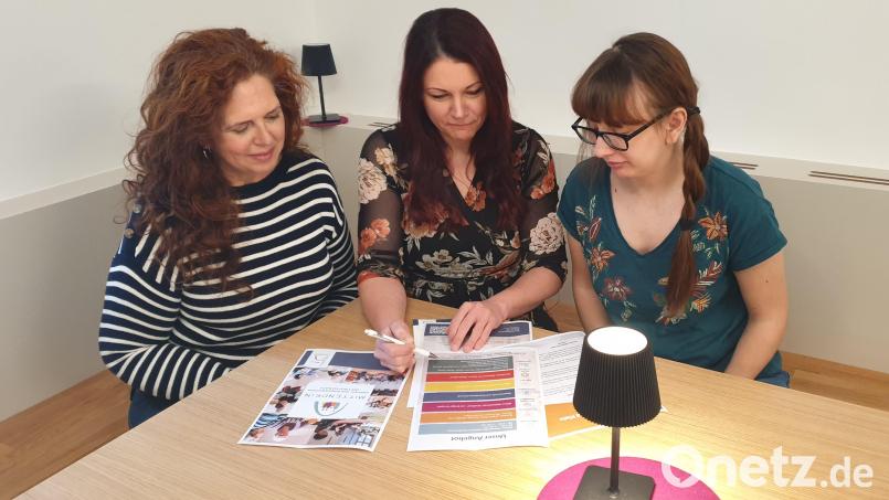 Mittendrin-Leiterin Jessika Wöhrl-Neuber (Mitte), Kerstin Graf (links) und Deborah Bregler besprechen den Entwurf des neuen Mittendrin-Flyers, den Carolin Böckl vom Stadtmarketing gestaltet hat. Bild: Manfred Spiegler