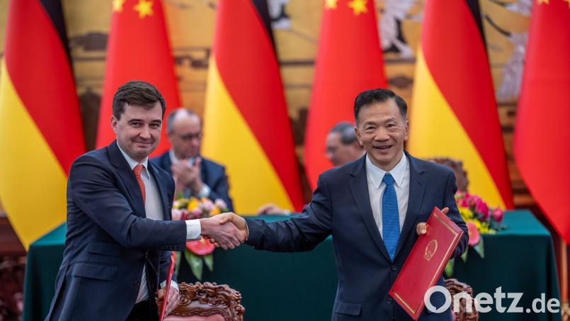 DFL-Geschäftsführer Steffen Merkel (l) und Shen Haixiong, Präsident der China Media Group CMG, nach der Unterzeichnung der Absichtserklärung. Bild: Michael Kappeler/dpa