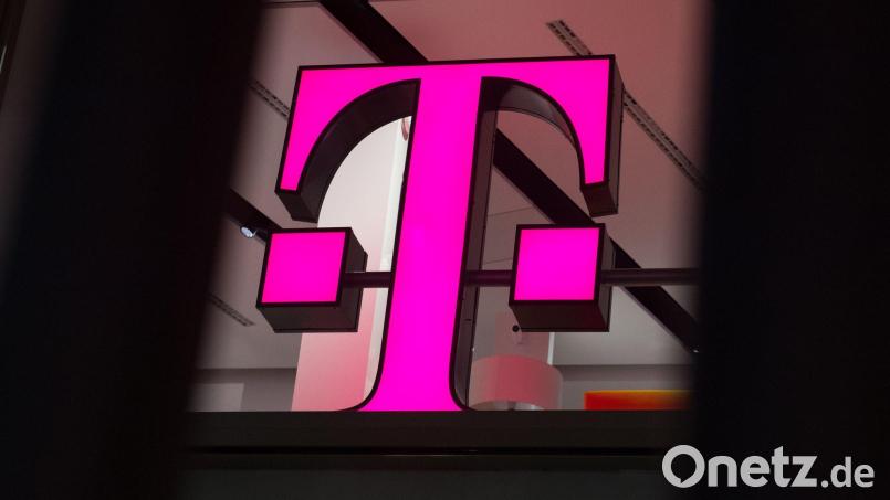 Ein Telekom-Logo strahlt in Magenta - für den Konzern sind die Behördenpläne eine gute Nachricht. Bild: Rainer Jensen/dpa/dpa-tmn