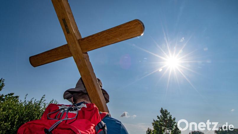 Ein Pilger trägt während der größten Fußwallfahrt Deutschlands ein Holzkreuz: Die Anmeldung für die Regensburger Diözesanfußwallfahrt nach Altötting ist ab März möglich. Archivbild: Armin Weigel/dpa