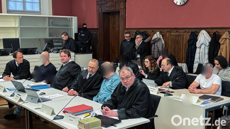 In drei Tischreihen sitzen die fünf Angeklagten mit ihren Anwälten im Bandenprozess beim Landgericht in Amberg. Bild: Stephan Huber