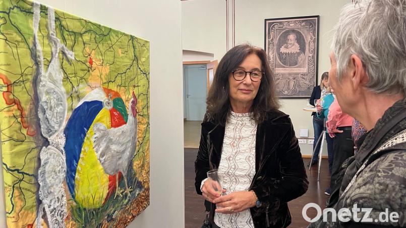 Monika Bugl, Reporterin bei Oberpfalz-Medien, (hier im Gespräch mit einer Besucherin der Ausstellung) führt in ihrer Freizeit den Pinsel. Auf alten Schullandkarten erschafft sie ihre Bilderwelten. Bild: ihl