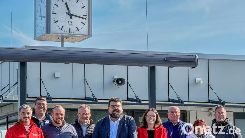 Strahlen mit der Frühlingssonne um die Wette, von links: Martin Dunst, Alfons Ostler, Christian Weiß, Gerhard Egelseer, Stefan Frank, Sonja Kalb, Hans-Jürgen Reitzenstein, Anke Kaltenbach und Thomas Retzer vor der neuen Analog-Uhr am Bademeisterhaus. Bild: Wolfgang Steinbacher