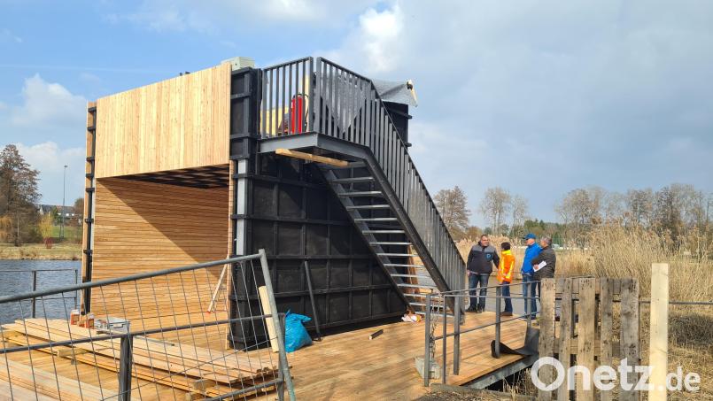 Stadtpressesprecher Mirko Streich, Bauamt-Projektleiter Lutz Zangl, Bauhofleiter Reinhard Legat und Jürgen Scharnagl (von rechts), betrachten den wieder aufgebauten Storchenpavillon der noch einer Baustelle gleicht, aber bereits in einer Woche Besucherinnen und Besuchern eine hervorragende Aussicht über das Gartenschaugelände und auf die Altstadt bieten soll. Bild: Jonas Storch
