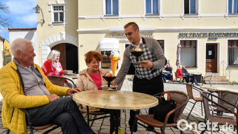 Strahlende Sonne, lachende Gesichter: Bei Frühlingswetter am Freitagnachmittag (21. April) genießen die Urlauber Leonhard und Petra Schuster aus Oberasbach bei Nürnberg einen Frucht- und einen Joghurteisbecher von Mario de Marco (rechts) im Eiscafé Sommariva. Bild: Petra Hartl