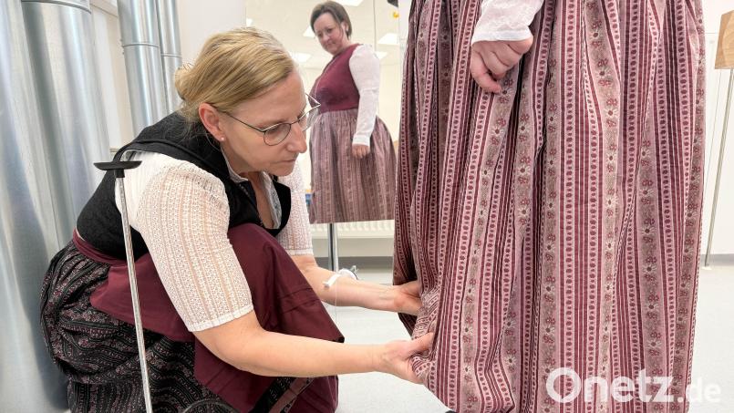 "Es sollte ein Maßkrug drunter passen", wird oft die Länge eines traditionellen Dirndls beschrieben. Kurleiterin Elfriede Brandl zeichnet an, wo gekürzt werden muss. Bild: Gabi Schönberger