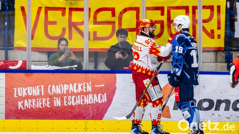 Travis Turnbull schnappt sich den Weidener Alex-Olivier Voyer während die Kaufbeurer Fans im Hintergrund ihrem Frust mit einem Banner freien Lauf lassen. Am Ende drehen die Joker eine verloren geglaubte Partie noch und erkämpfen sich ein weiteres Spiel in der Serie. Bild: Tobias Neubert