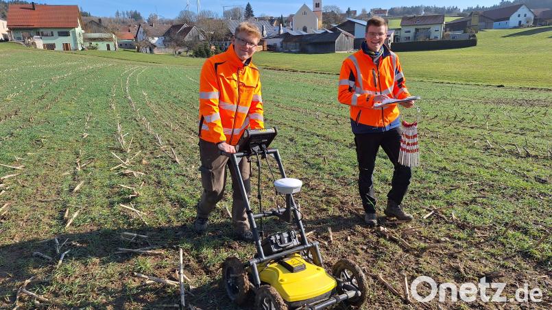 Lukas König (links) schiebt das Bodenradar übers Feld, sein Studienkollege Jonas Müller setzt die großen Stecknadeln, die Fixpunkte auf dem Gelände markieren. Bild: bl