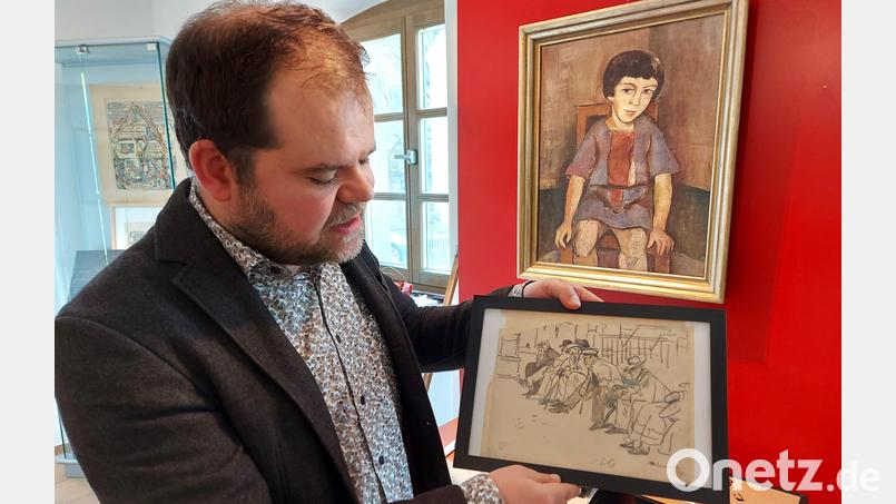 Christoph Ahlemeyer zeigt eine Zeichnung aus dem Zyklus „Weltkriegsstimmung“ von 1916. Dahinter befindet sich das Porträt eines sitzenden Mädchens, möglicherweise ein Selbstporträt der Künstlerin. Bild: lg