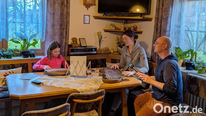 Thea, die Enkelin der betreuten Senioren, mit Marina Rischan beim Zitherspiel und BR-Reporter Tobias Föhrenbach. Bild: hdk