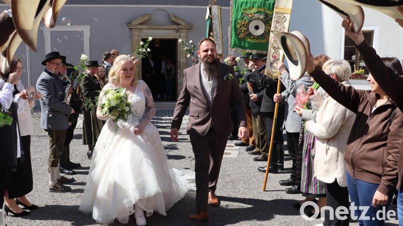 Tamara Reichert und Andreas Graf durchschritten nach der Hochzeit das Spalier von Freunden und Vereinskameraden, unter anderem der Schützen. Bild: mrr