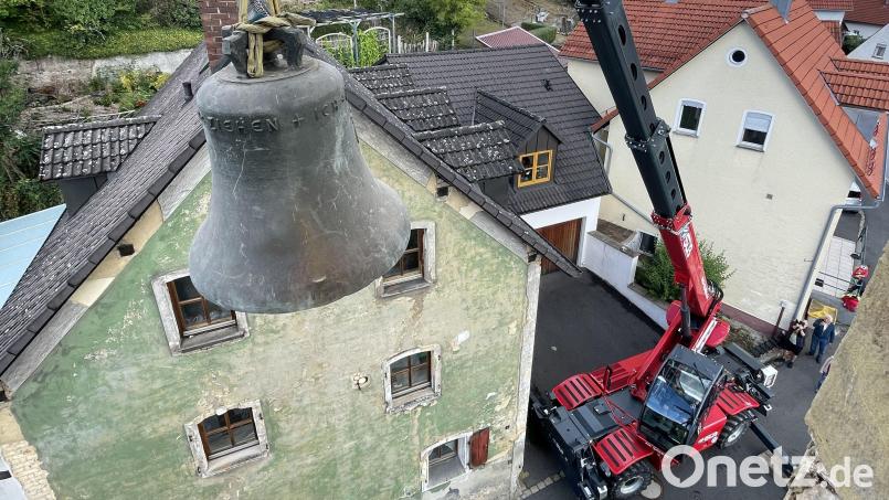Die alte Glocke schwebt am Kranhaken aus dem Kirchturm heraus und über der Kirchgasse – eine Spezialoperation, die es so in Rosenberg lange nicht mehr zu sehen geben wird. Bild: Alfons Götzfried