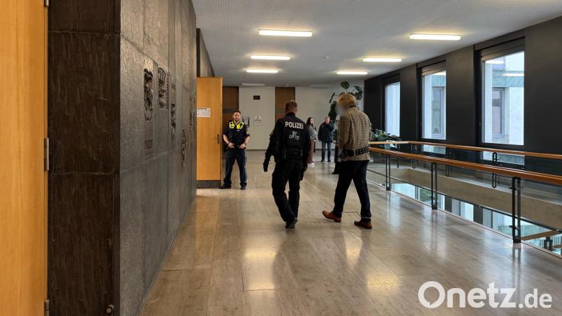 Der Angeklagte wird mit Hand- und Fußfesseln, verbunden über eine Bauchbinde, in den Sitzungssaal geführt. Bild: Stefanie Tretter