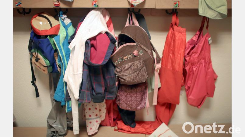 Jacken und Rucksäcke von Kindern hängen in einer Kita. In Königstein wird die Kindertagesstätte demnächst fertig gestellt. Der Marktrat befasste sich auch mit den Gebühren für die Betreuung der Kinder. Symbolbild: Fredrik von Erichsen/dpa