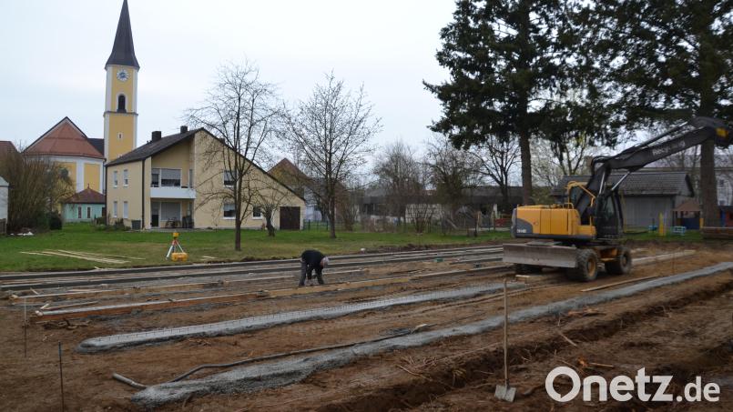 Der Einbau der Fundamente für die Container-Übergangslösung während der Zeit des Kindergartenbaues läuft bereits. Im Hintergrund sind das Pfarramt, der Kindergarten und die Pfarrkirche zu sehen. Bild: gi