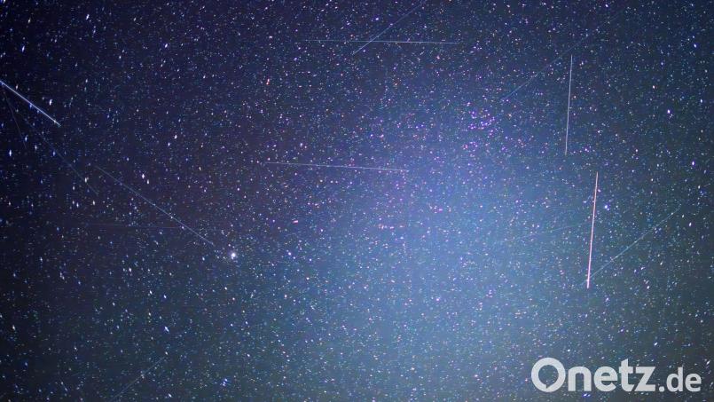 Erdnahe Satelliten sind auf Langzeitbelichtungen als Lichtspuren zu erkennen. Das bayerische Start-Up Mynaric baut Laserfunkterminals für Satelliten und ist nun von einem US-Konzern übernommen worden. (Symbolbild) Bild: Patrick Pleul/dpa