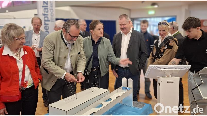 Kurz nach der Eröffnung des "Schaufenster Nabburg": Bürgermeister Frank Zeitler (vorne Zweiter von links) und MdB Tina Winklmann (rechts daneben) versuchen sich am "heißen Draht" beim Stand von EMZ, einem der größten Arbeitgeber in der Stadt Nabburg. Bild: jua