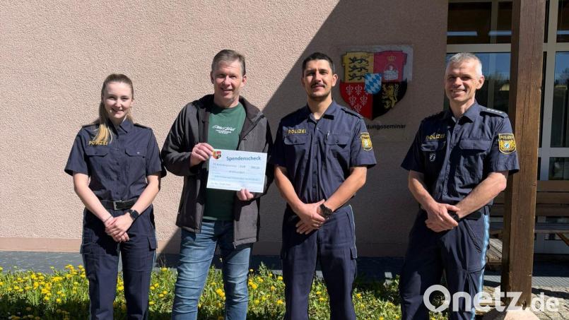 Die Polizeischüler Ebner (links) und Bodur (Zweiter von rechts) übergeben den Scheck gemeinsam mit ihrem Ausbilder, Hauptkommissar Breu (rechts), an Marco Kind von der Selbsthilfegruppe Krebskranker Kinder. Bild: POW Dudko, VII. BPA, 73. AS