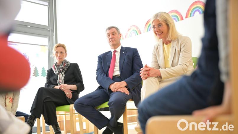 Bunte Regenbögen an der Wand und ein Stuhlkreis: In dieser Umgebung stellen sich Karin Prien, Markus Söder und Ulrike Scharf den Fragen von Vorschulkindern. Bild: Malin Wunderlich/dpa