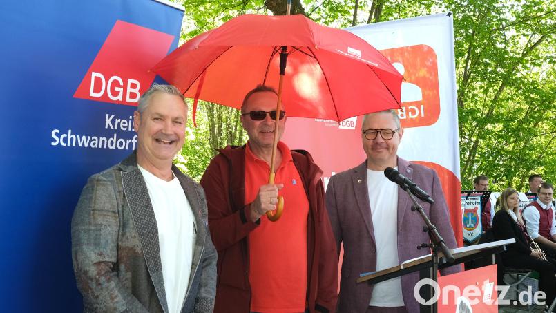 DGB-Kreisvorsitzender Wolfgang Kurzendorfer (links) und sein Stellvertreter Andreas Sander (rechts) bedankten sich beim Hauptredner der Maikundgebung in Schwandorf, Udo Fechtner (Mitte), mit einem Schirm. Bild: Hirsch