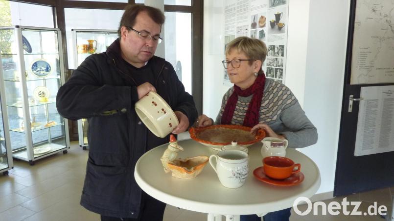 Pfarrer Haußmann, der ein Kenner der Schwarzenfelder Tonwaren ist und auch schon darüber referierte, mit Helga Katrin Stano, deren Mutter noch in der Heferlbude arbeitet. Sie trug mit Unterstützung von Herrn Linzmeier eine stattliche Sammlung von Steingutstücken aus der Tonwarenfabrik zusammen, die man im Eingangsbereich des Schwarzenfelder Rathaus sehen kann. In Pfarrer Haußmanns Hand eine Schüssel (Alltagsgeschirr) mit Schablonendekor. Die Tasse im Vordergrund ist das älteste Exponat und dürfte von 1905 sein. Der Krug rechts ist aus den 20er-30er Jahren. Tasse mit Untertasse ist minderwertige Kriegsware. Der Obstteller und die Nippesfigur haben Laufglasur. Bild: Archiv Helga Katrin Stano