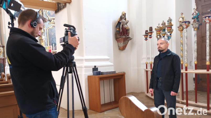 Der Kunsthistoriker Daniel Rimsl berichtet in der Filmreihe „Schmuckstücke im Bistum Regensburg“ über die Prozessionsstangen in der Vilsecker Pfarrkirche (rechts hinter Rimsl). Bild: Dorothee Schulze Zumhülsen