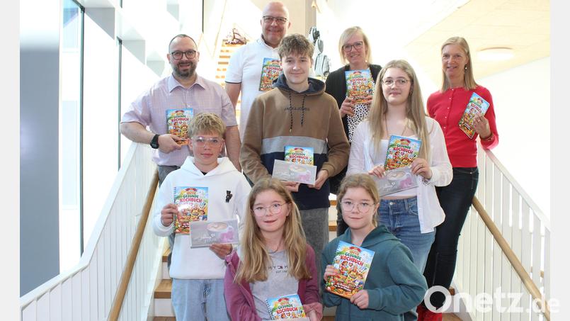 Mit Schülerinnen und Schülern, die auch Rezepte beigesteuert haben, präsentieren Realschuldirektor Holger König, Beratungsrektor und Initiator Walter Thurn (hinten, von links) sowie die Fachoberlehrerinnen Andrea Hildebrand und Kathrin Kohl (rechts) von der Fachschaft "Ernährung und Gesundheit das gesunde Kochbuch. Archivbild: Hermann Daubenmerkl