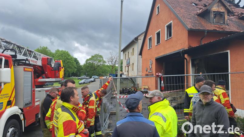 Noch Stunden nachdem der Brand gelöscht ist, stehen Helfer und Anwohner bestürzt vor der Ruine des Feuerwehrhauses im Pfreimder Ortsteil Untersteinbach. In wenigen Wochen sollte auf der Wiese nebenan das 150-jährige Bestehen der Feuerwehr Iffelsdorf gefeiert werden. Bild: bl