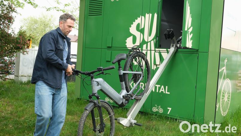 Der Geschäftsführer der Sunshine-Bikes-GmbH, Sebastian Bernhard, erklärt den Verleihvorgang an der Fahrradbox auf dem Schwandorfer Volksfestplatz. Bild: Hirsch