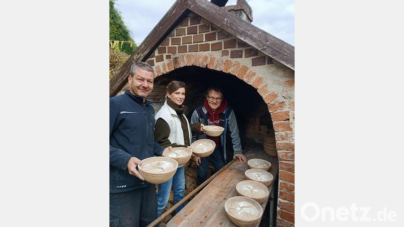Uli Piehler (rechts) schürt zusammen mit seinen Mitstreitern den Dorfbackofen in Wutschdorf und schießt die Teiglinge ein. Bild: privat