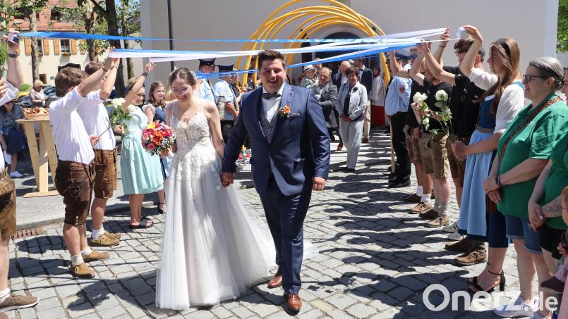 Magdalena und Phillip Haas durchschritten nach der kirchlichen Trauung in Rieden ein Spalier der Vereine. Bild: mrr