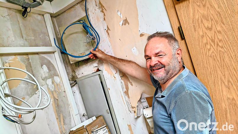 Gebäudeeigentümer Gerald Sacher hat den Humor noch nicht verloren. Er hält das Ende des Kabels in Händen, das im August 2025 gelegt wurde, von dem jedoch niemand mehr etwas weiß und das deshalb für die Telekom nicht existent ist. Bild: Gerd Pöhlmann
