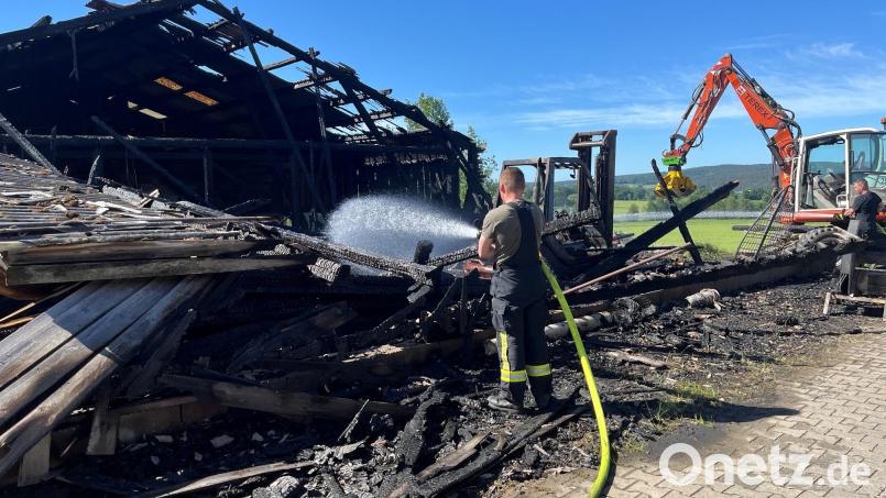 Der Brand der Maschinenhalle in Oberpfreimd ist schnell unter Kontrolle. Im Nachgang ist es wichtig, dass die Flammen nicht wieder auflodern. Dafür unterstützt ein Bagger die Feuerwehrleute. Bild: ihl