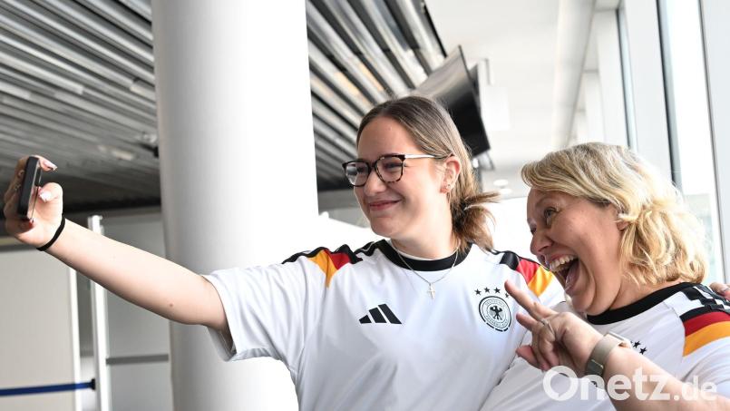 Glückliche Passagiere: Auch Leonie und Anja bekamen ein Deutschland-Trikot vor dem Linienflug mit der Nationalmannschaft nach Chicago. Bild: Federico Gambarini/dpa