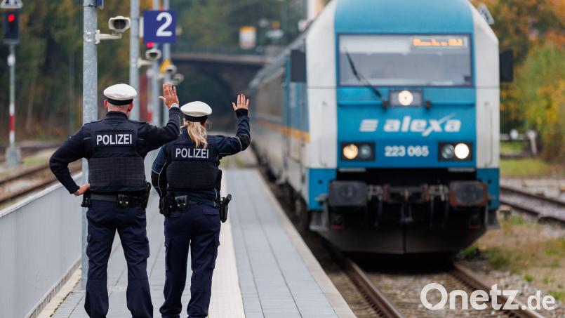 Bundespolizisten weisen per Handzeichen den Lokführer eines Zuges aus Prag in Richtung München darauf hin, dass sie zur Kontrolle des Einreiseverkehrs zusteigen werden. (Archivbild) Bild: Daniel Karmann/dpa