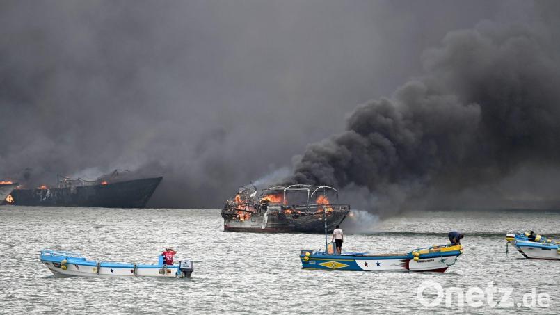 Im Hafen von Manta stehen mehrere Fischerboote in Flammen. Bild: Ariel Ochoa/AP/dpa