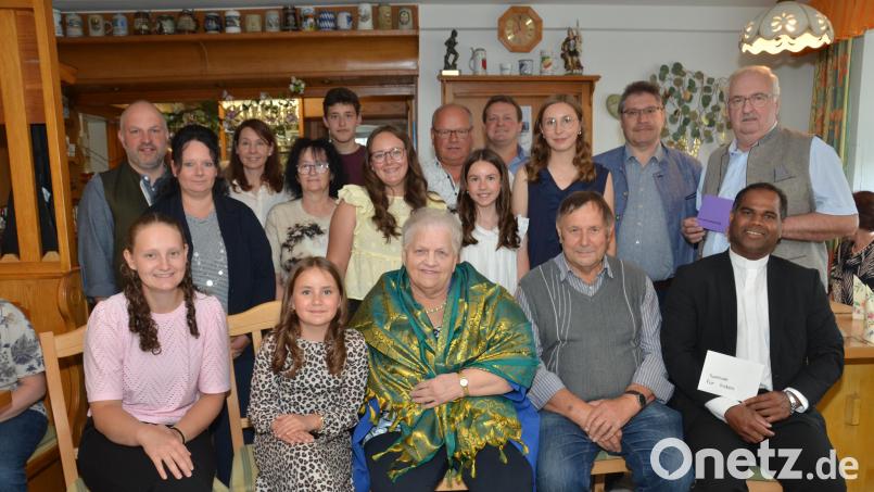 Inmitten ihrer Gäste mit Lebenspartner Karl Burger (vorne, Zweiter von rechts), Kindern und Enkeln, Bürgermeister Wolfgang Bock (hinten, Zweiter von rechts), sowie Spendenempfänger Pfarrer John Subash Vincent (rechts) und Herbert Putzer von der Kinderkrebshilfe (hinten, rechts) feierte Helga Müller (vorne, Mitte) ihren 80. Geburtstag nach. Mit einem edlen grün-goldenen Seidentuch aus seiner Heimat überraschte sie der Geistliche. Bild: Elisabeth Dobmayer
