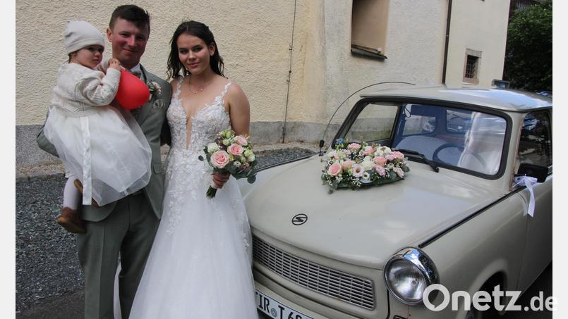 Johanna und Jonas Zölch mit ihrem gemeinsamen Töchterchen Emma und ihrem Hochzeitsauto, einem Trabi. Bild: Konrad Rosner