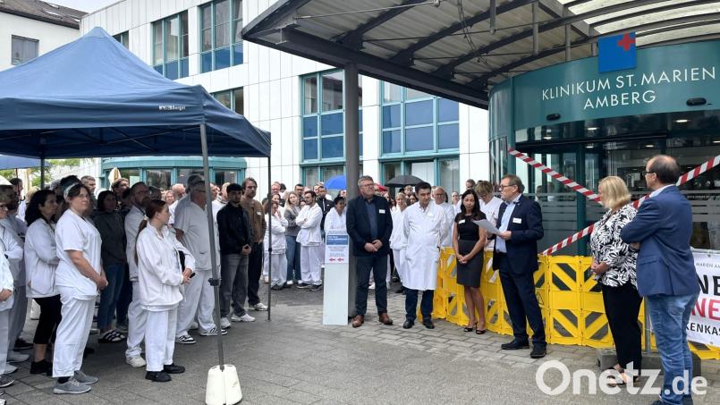 Mit einer symbolischen Sperrung des Haupteingangs beteiligten sich am Freitagmittag der Vorstand des Klinikums St. Marien Manfred Wendl (3.v.r.) und mit ihm (von rechts) Personalratsvorsitzender Reinhard Birner, Pflegedirektorin Kerstin Wittmann, Ärztliche Direktorin Dr. Ramona König, der Chefarzt der Gefäßchirurgie und Gefäßmedizin Dr. Saman Djamil, der Kaufmännische Direktor Hubert Graf sowie zahlreiche Mitarbeitende an der Protestaktion, zu der die Bayerische Krankenhausgesellschaft die Kliniken aufgerufen hatte. Bild: Susanne Schwab