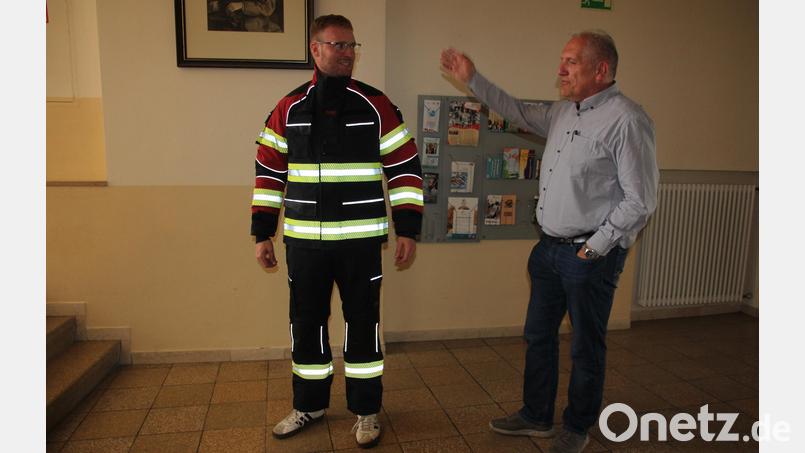 Röthenbachs Zweiter Kommandant Jonas Zeitler präsentierte Bürgermeister Werner Prucker und dem Gemeinderat den neuen Schutzanzug. Bild: Konrad Rosner
