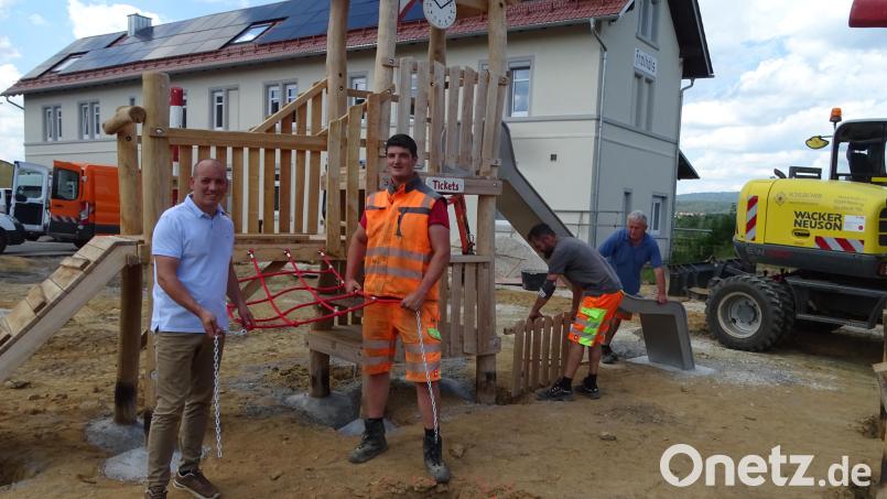 In Freihöls sorgen Bauhofbedienstete dafür, dass vor dem Bahnhofsgebäude ein eingezäunter Spielplatz entsteht. Bürgermeister Florian Adam (links) besuchte die Baustelle und dankte seinen Mitarbeitern. Bild: Houschka Bild: Wolfgang Houschka