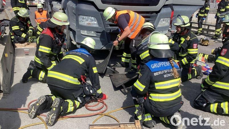 Um die Radlerin zu befreien, demontierten die Einsatzkräfte Bodenteile des Lasters. Bild: -/Berufsfeuerwehr München/dpa