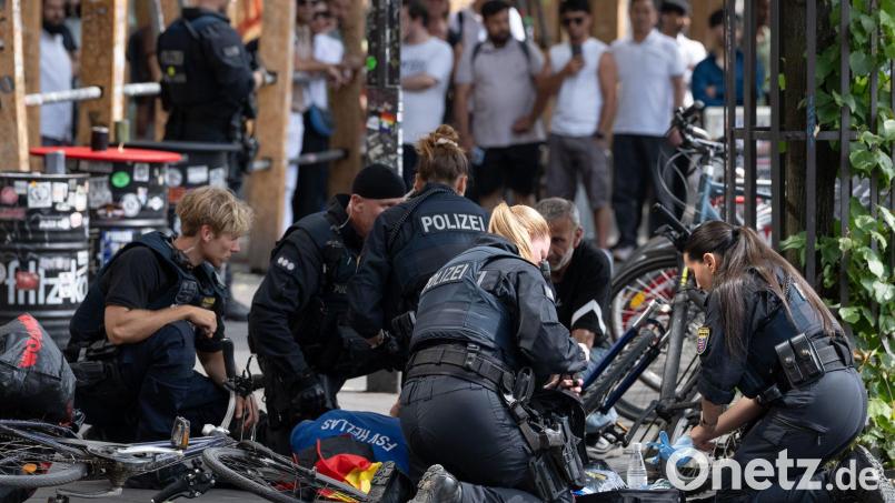 Polizisten knien in der Nähe des Frankfurter Hauptbahnhofs am Boden und kümmern sich um einen Verletzten. Bild: Boris Roessler/dpa