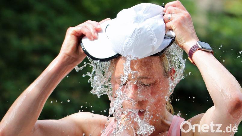 Eine Läuferin beim Hamburger Halbmarathon erfrischt sich an einer Wasserstelle. (Symbolbild) Bild: Markus Tischler/dpa