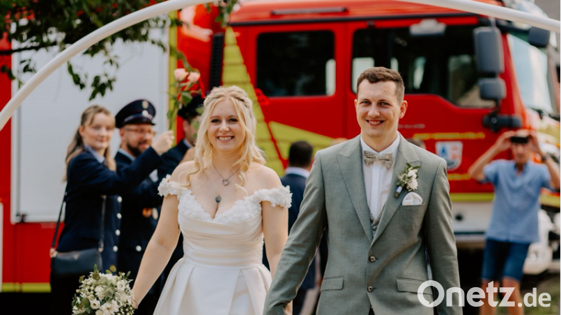 Das frisch vermählte Paar Laura und Dominik Friedl nach dem Durchschreiten des Schlauchspaliers der Feuerwehr Oberköblitz. Bild: Andrea Kammerer