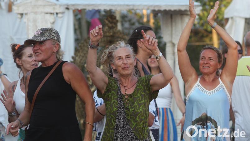 Die Teilnehmer am Yoga-Festival am Steinberger See genießen die abendliche Stimmung und meditieren zur Musik. Bild: Rudolf Hirsch
