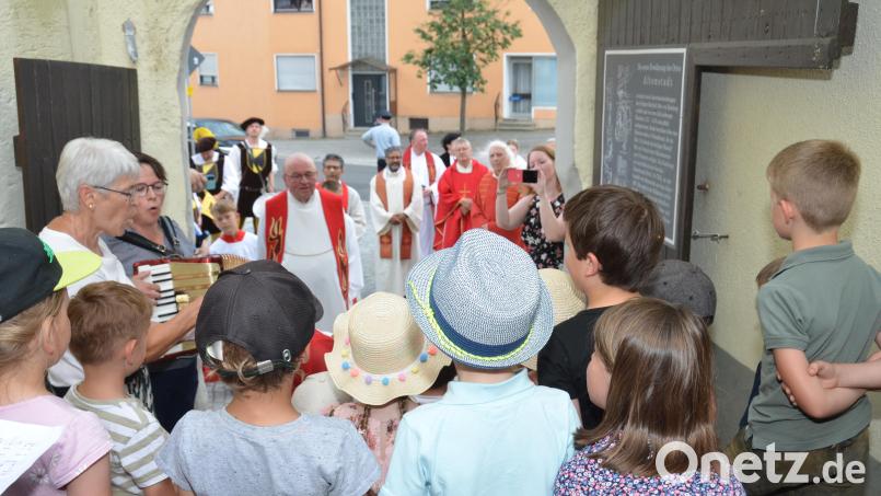 Kindergartenkinder aus Tännesberg gehörten zu den ersten Gratulanten und überraschten Pfarrer Wilhelm Bauer gleich am Torbogen zur Kirche mit einem selbst gedichteten Lied, das Leiterin Manuela Hinkel auf dem Akkordeon begleitete. Bild: Elisabeth Dobmayer
